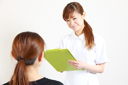 young japanese nurse talks with patient